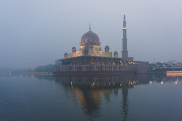 Fototapeta na wymiar Putra Mosque, Putrajaya, Malaysia seen through thick morning haze 