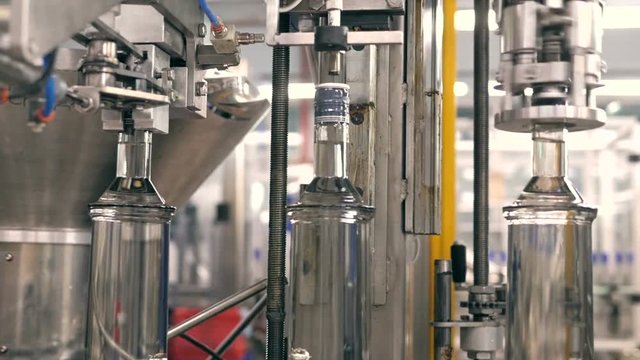 bottling water on the plant. Cap tightening of vodka on factory bottling plant