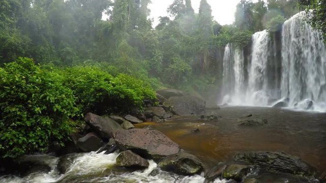 Curtain of whitewater tumbles and roars over the brink of a natural waterfall at Phnom Kulen National Park in Cambodia, with sound. Video UltraHD