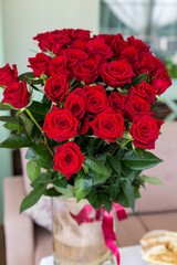 beautiful big bouquet of roses in a vase standing on the table