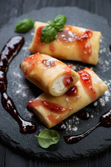 Crepes with cottage cheese, served with jam and sugar powder