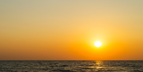 Fototapeta na wymiar Horizontal vibrant orange ocean sunset background backdrop