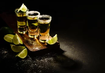 Foto op Plexiglas Mexican Gold Tequila with lime and salt on wooden table, selective focus. Copyspace. © FoodAndPhoto