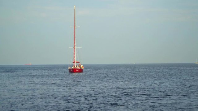 The yacht with the lowered sails on the high seas. View from the ship sailing. Active camera
