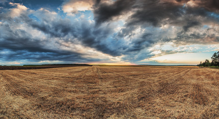 Dramatic clouds over the field after harvest