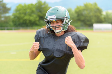 Motivated young woman playing American football