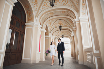 Fototapeta na wymiar Beautiful couple, bride and groom posing near big white column