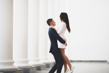 Beautiful couple, bride and groom posing near big white column