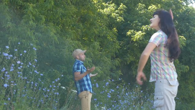 Large woman scolds the small man. Young couple having fight in summer park. A tall woman blames low husband.