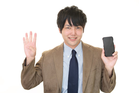 スマートフォンを持つ笑顔のビジネスマン - Powered by Adobe