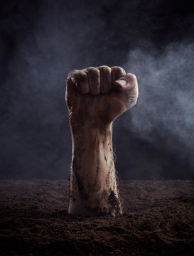 Clenched fist climbs out of the ground