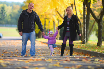 Young happy family on walk in autumn park
