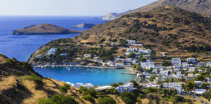 Panoramic aerial-like view of Kini village and emerald bay in Syros island. Traditional Cycladic architecture and scenic coast of Siros, Greece.