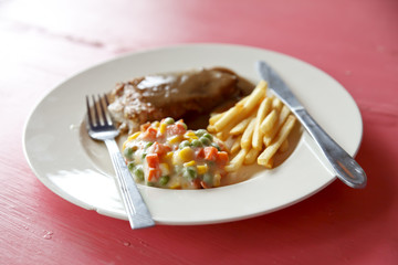 Steak on white plate on wooden background