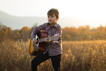 Boy with guitar in autumn