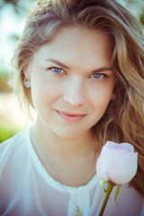 Portrait of young woman with pink rose flower