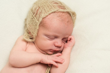 Newborn baby sleeping with hand under his cheek