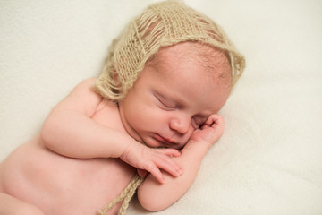 Newborn baby sleeping with hand under his cheek