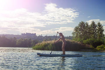 SUP silhouette of young girl paddle boarding at sunset10