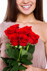 Fototapeta na wymiar Perfect gift. Closeup shot of unrecognizable smiling woman, holding bunch of roses while standing isolated on white background.