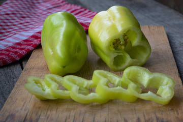Photo of sliced green bell peppers over wooden table