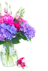 Bright pink peony, eustoma and blue hortensia flowers bouquet in vase close up isolated on white background