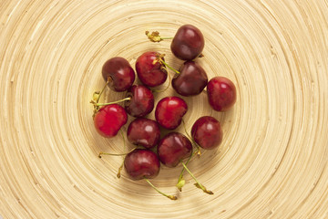 Photo of bright cherries, shot from above on bamboo plate