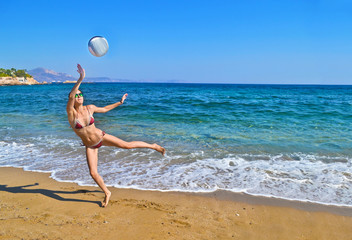 woman playing volleyball at a greek beach - greek summer photo