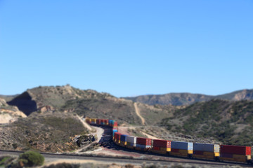 Fototapeta na wymiar Train going through mountains, tilt shifted image