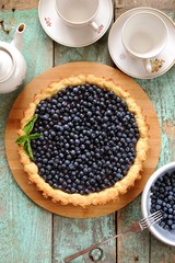 Homemade open tart decorated with fresh organic wild blueberries