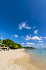 Mauritius beach umbrellas, thatch. Tropical Mauritius island water & beach resort, Turtle Bay -...