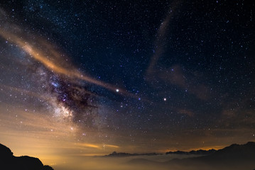 The colorful glowing core of the Milky Way and the starry sky captured at high altitude in summertime on the Italian Alps, Torino Province. Mars and Saturn glowing mid frame. - obrazy, fototapety, plakaty