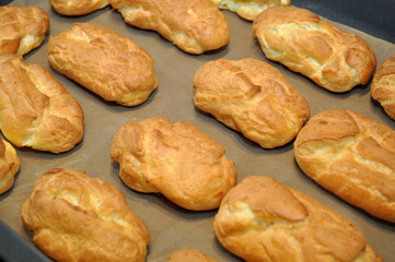many eclairs cakes closeup on the white paper