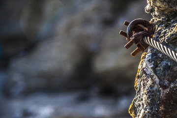 Rusty hook on sea rocks