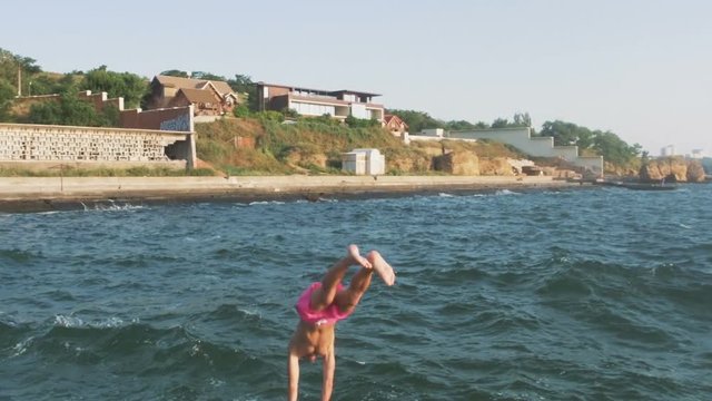 Guy Running And Jumping Off Sea Pier In The Water, Slow Motion