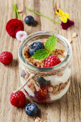 Glass jar with fruits and whipped cream.