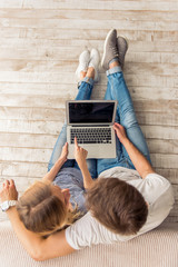 Beautiful young couple with gadget
