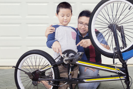 Father And Son Fixing Bike