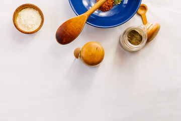 Blue bowl with spices, spices racks, wooden spoon and dehydrated