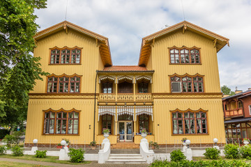 Fototapeta na wymiar Large yellow wooden mansion in Juodkrante