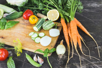 Closeup of fresh farmers market locally grown organic chopped vegetables on a cutting board. Wooden background.