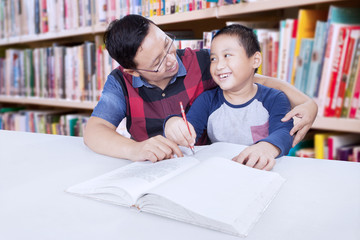 Teacher helps little boy to studying