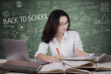 Teenage girl doing school task in class