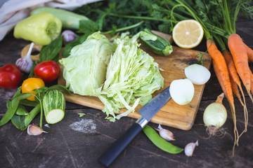 Closeup of fresh locally grown organic chopped vegetables on a cutting board.