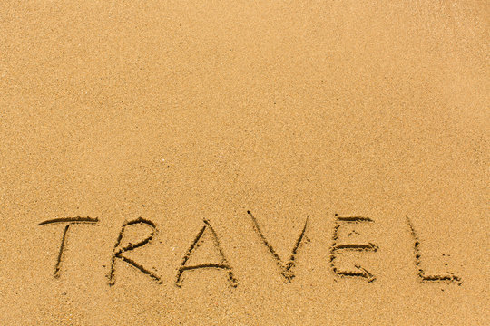 Travel - hand-written on the sand.