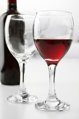 Glass of red wine with bottle on blurred interior background