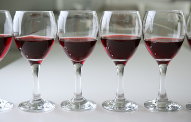 Glasses of red wine on white table closeup