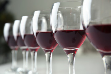 Glasses of red wine on white table closeup