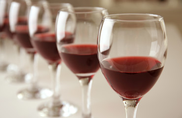 Glasses of red wine on white table closeup