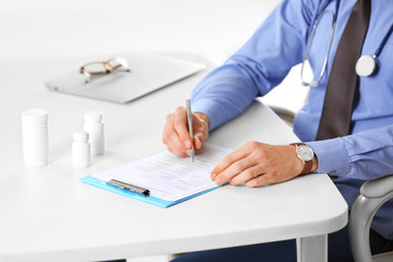 Doctor working at table in office